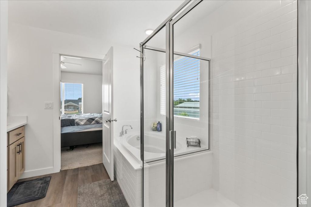 Full bath with wood finished floors, a shower stall, vanity, connected bathroom, and a bath