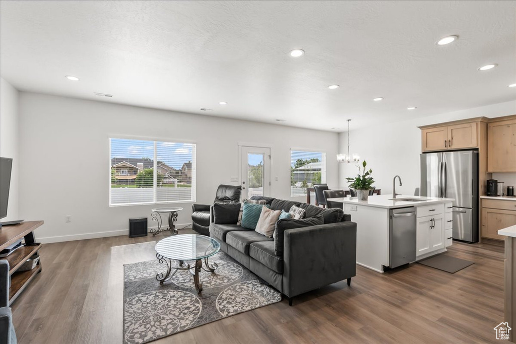 Living area featuring wood finished floors, recessed lighting, plenty of natural light, and a chandelier