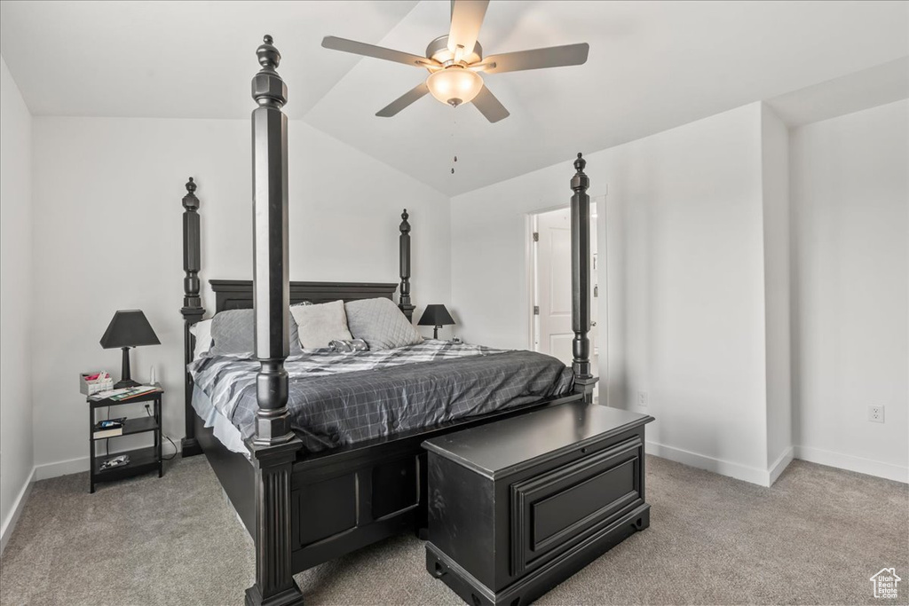 Bedroom featuring light colored carpet, vaulted ceiling, and ceiling fan