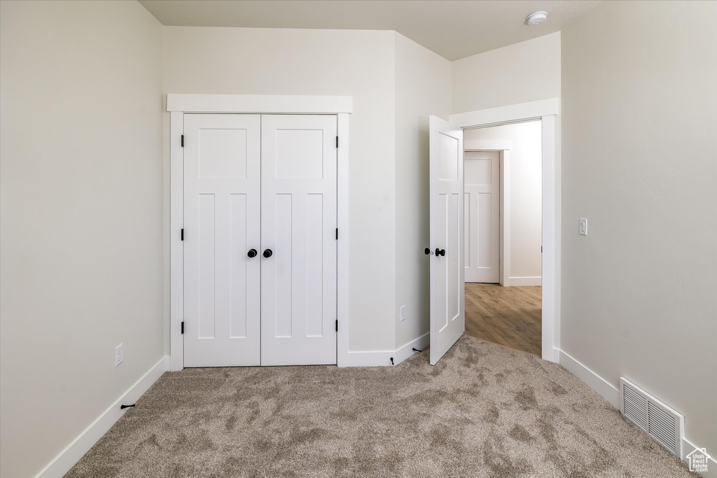Unfurnished bedroom featuring carpet floors and a closet