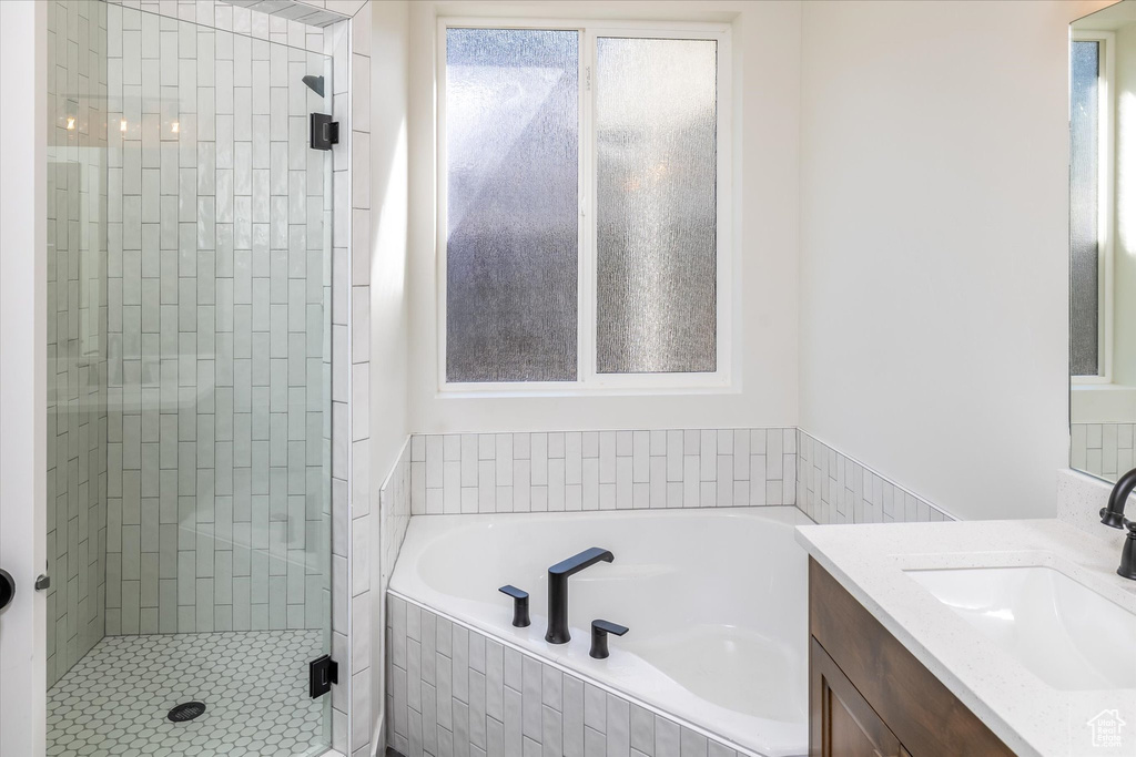 Full bath featuring a stall shower, vanity, and a garden tub