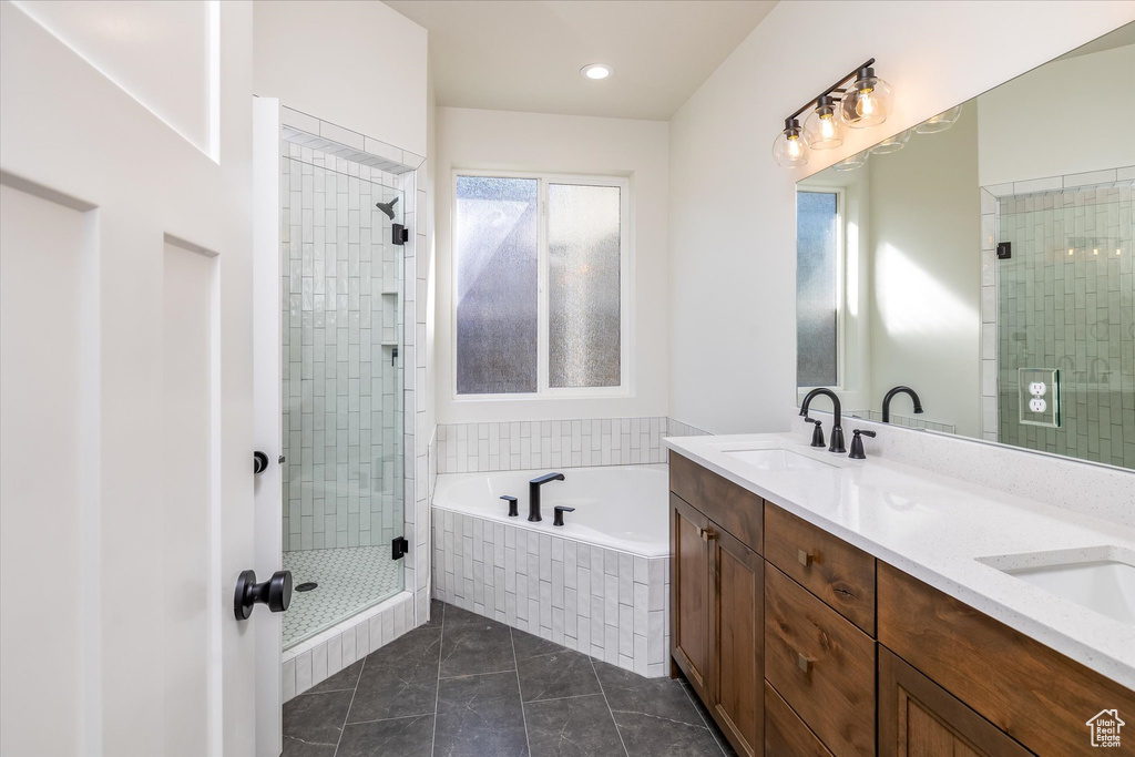 Bathroom with a shower stall, a bath, double vanity, and recessed lighting