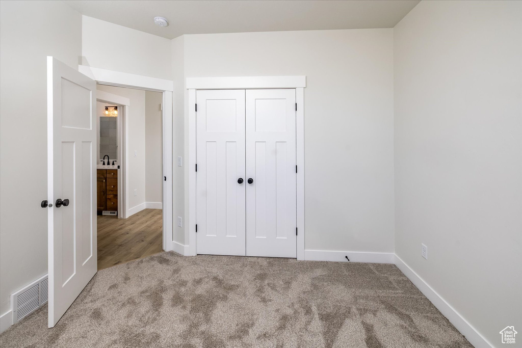 Unfurnished bedroom featuring carpet flooring and a closet