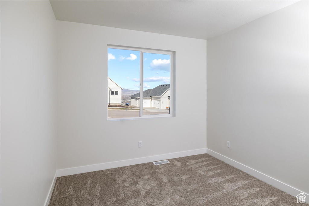 Unfurnished room with carpet flooring and baseboards