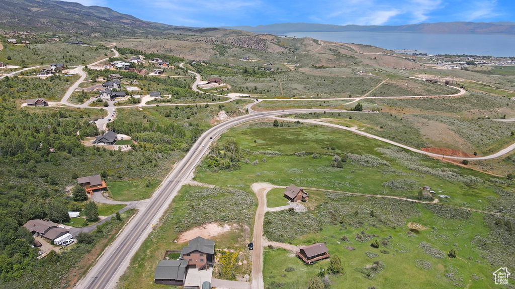Aerial view of property and surrounding area featuring a water and mountain view