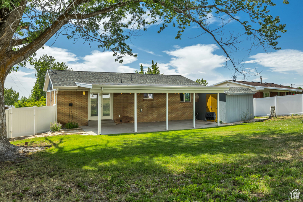 Rear view of property with brick siding, a patio, french doors, a gate, and a shingled roof