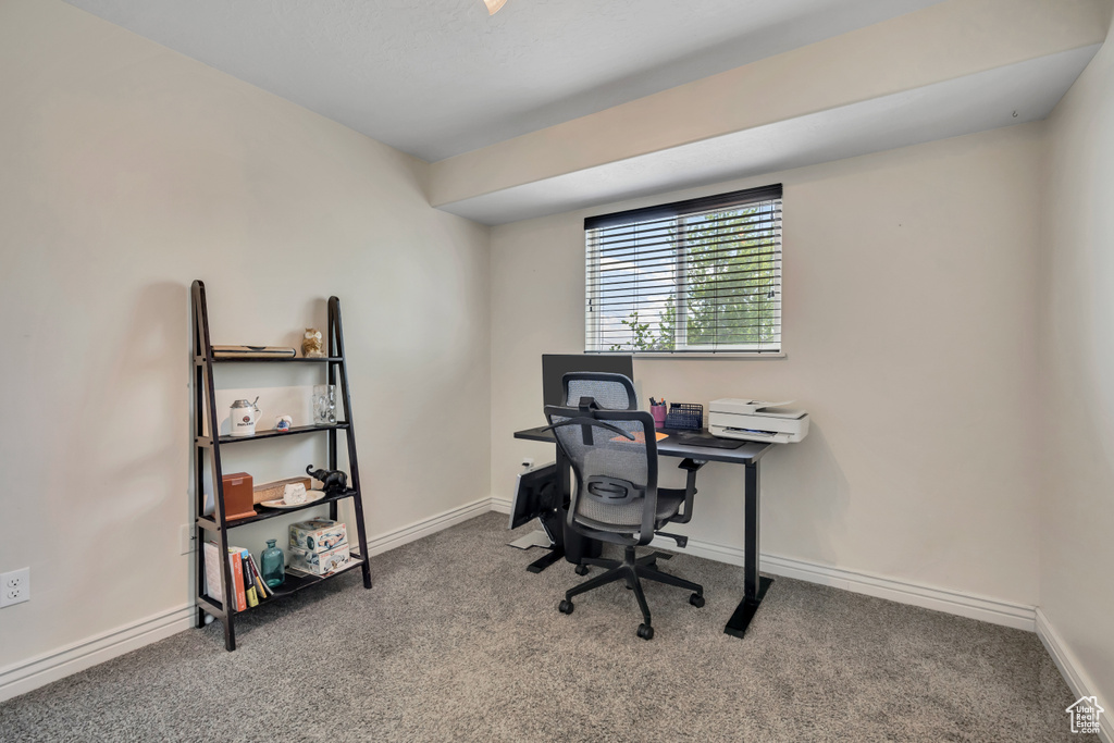 Carpeted home office featuring baseboards