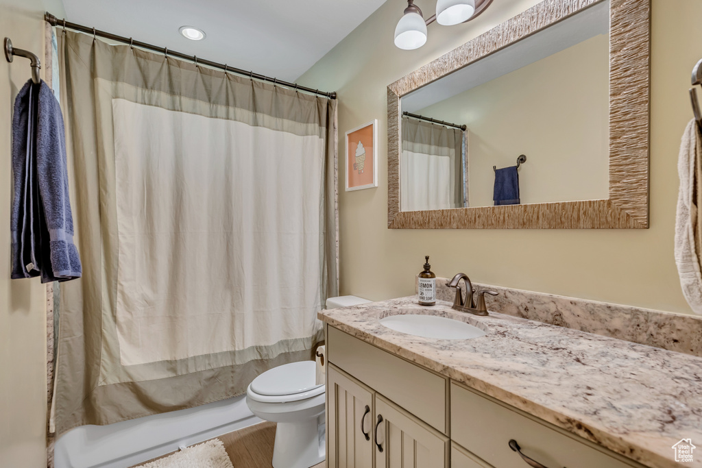 Bathroom featuring vanity, wood finished floors, and shower / bath combo with shower curtain