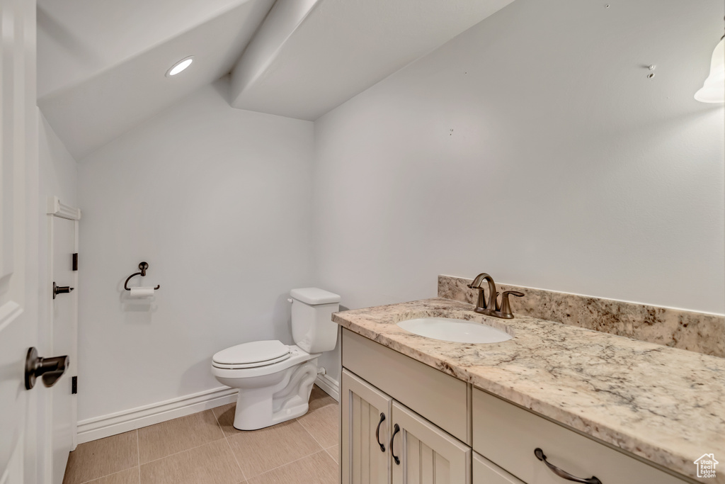 Bathroom featuring vanity and vaulted ceiling
