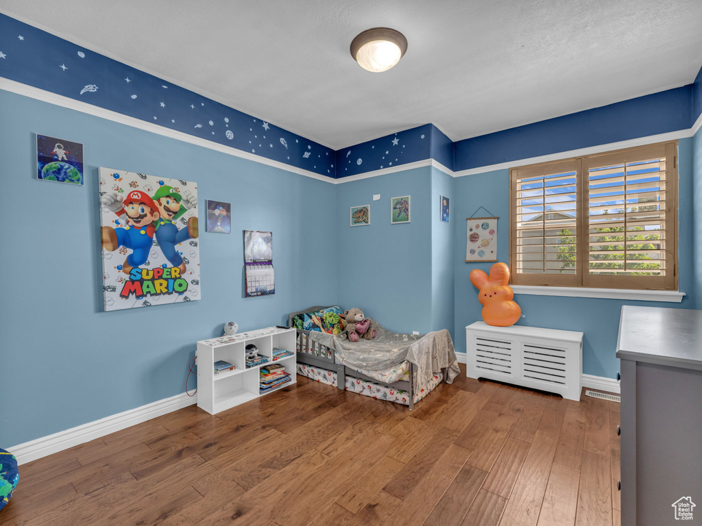 Bedroom featuring hardwood / wood-style flooring and baseboards