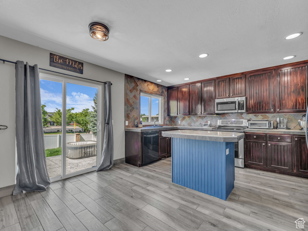 Kitchen featuring appliances with stainless steel finishes, light countertops, recessed lighting, and healthy amount of natural light