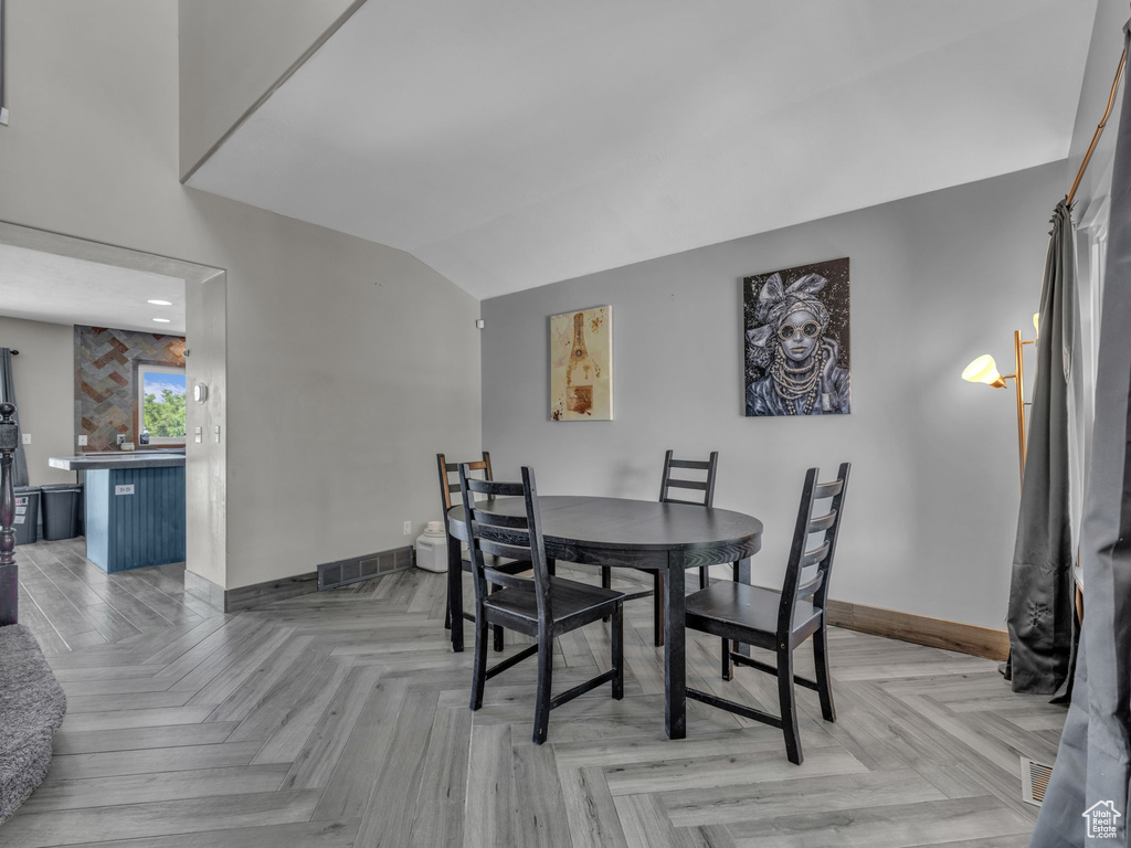 Dining space with baseboards and lofted ceiling