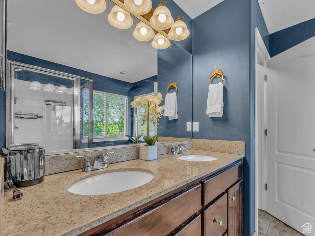 Full bath featuring double vanity and a stall shower