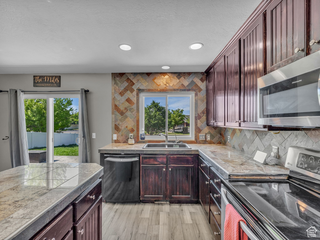 Kitchen featuring stainless steel appliances, tasteful backsplash, recessed lighting, and light wood-style floors