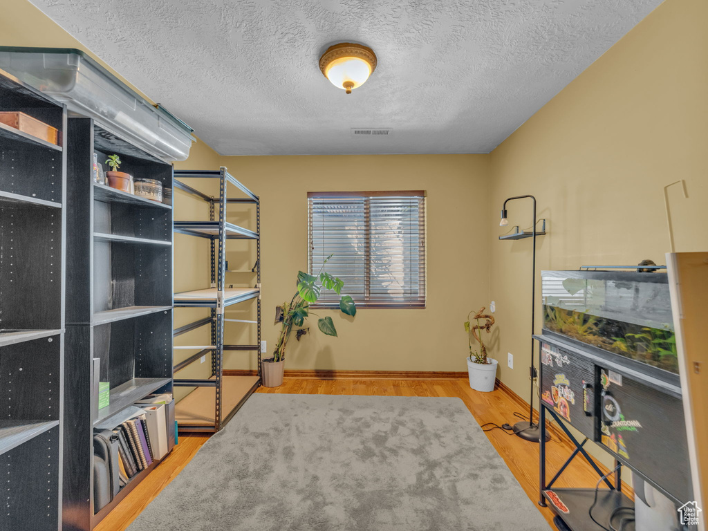 Office space featuring a textured ceiling and wood finished floors