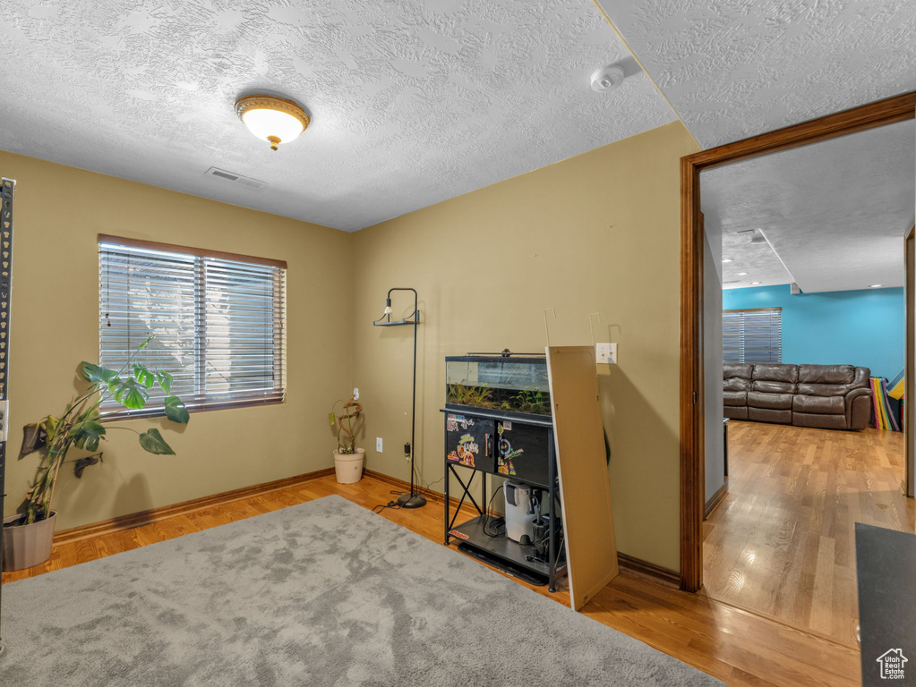 Office with a textured ceiling and wood finished floors