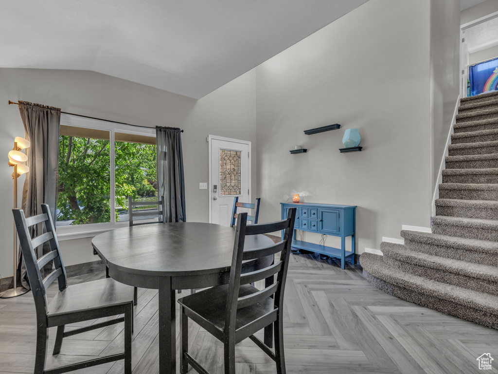 Dining area featuring vaulted ceiling and stairway