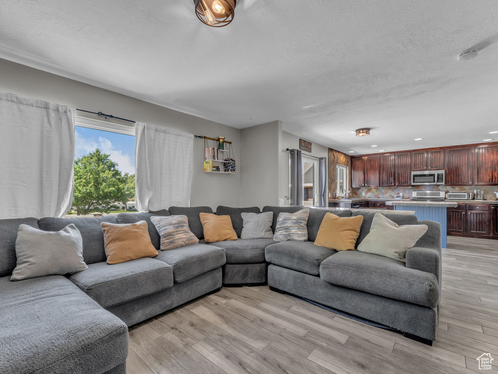 Living room with light wood-style floors and a textured ceiling