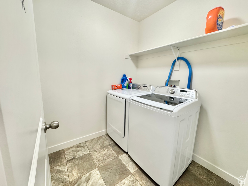 Washroom with separate washer and dryer and baseboards