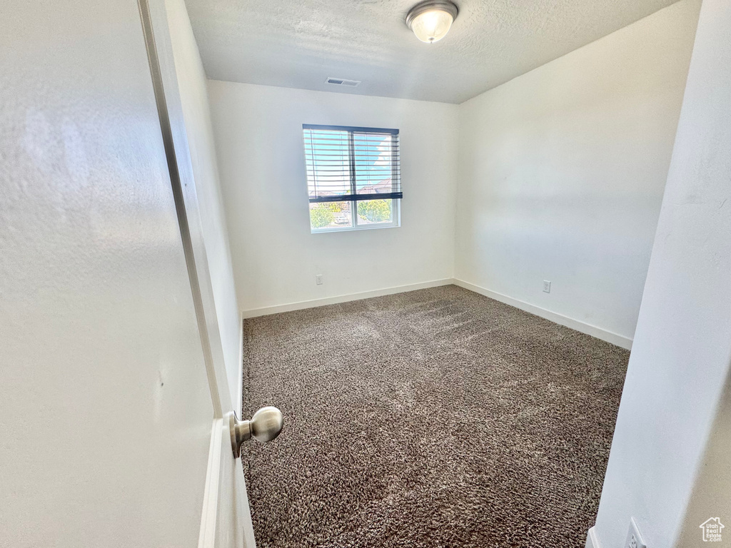 Spare room with a textured ceiling and carpet flooring