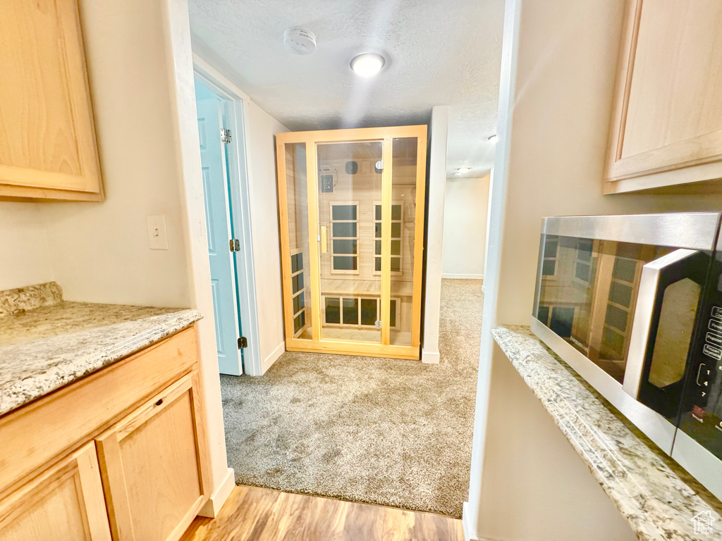 Relaxing sauna / steam room with wood finished floors and baseboards
