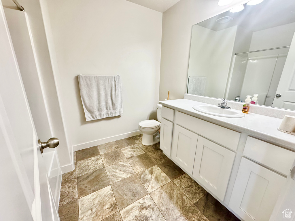 Bathroom with stone tile floors, vanity, and a shower
