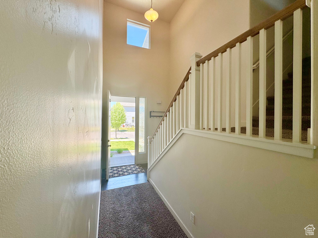 Foyer with carpet, a towering ceiling, and stairway