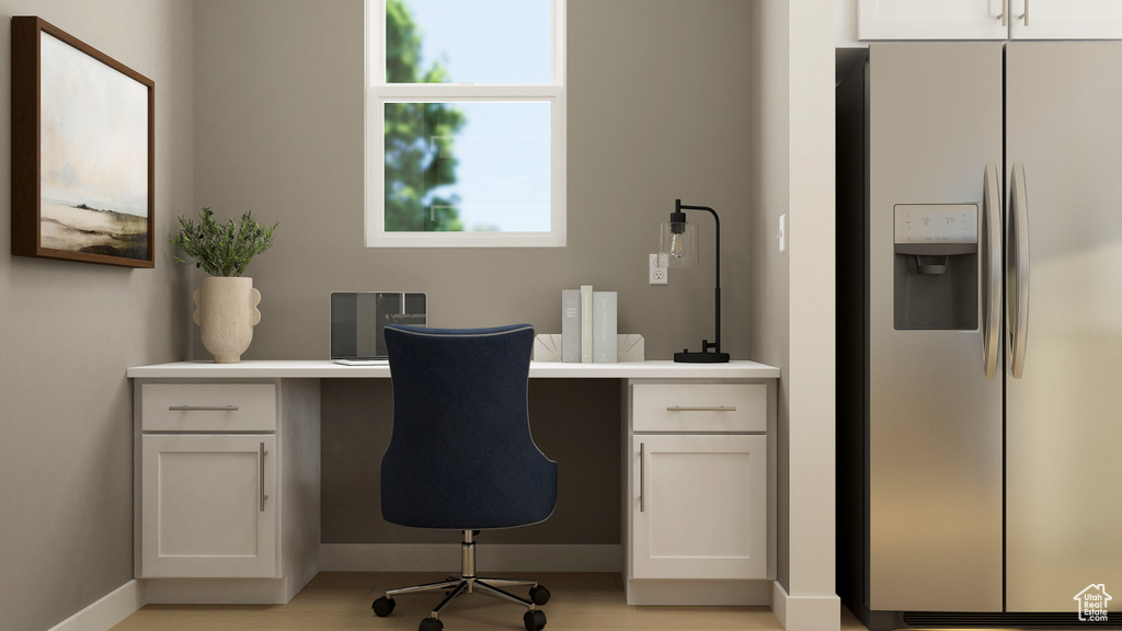 Office space with built in study area and light wood-style floors