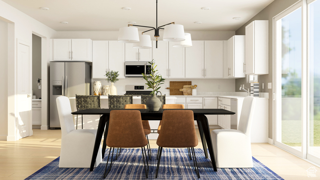 Kitchen featuring white microwave, stainless steel fridge with ice dispenser, light wood-style floors, and healthy amount of natural light
