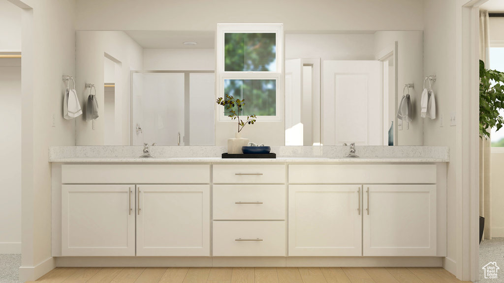 Full bathroom featuring double vanity, a shower, and wood finished floors
