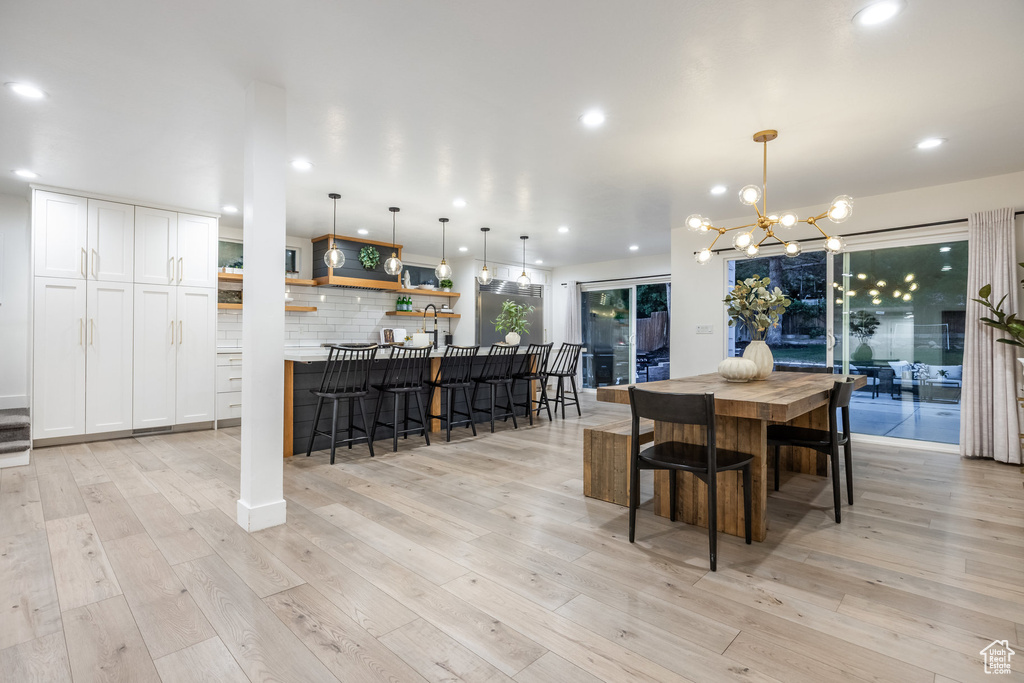 Dining room with a chandelier, light wood-style floors, and recessed lighting