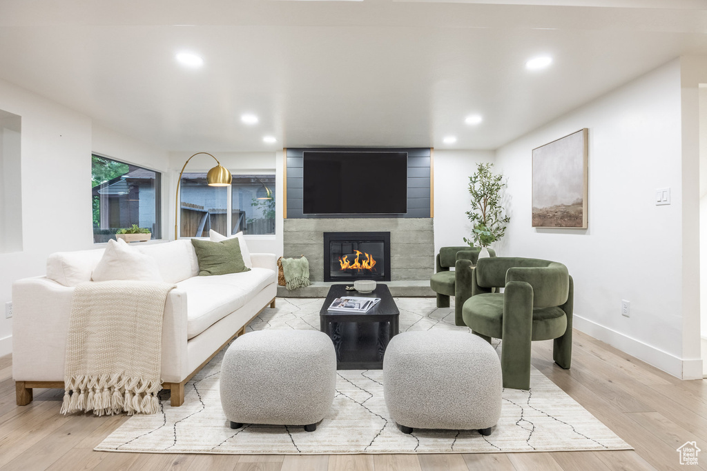 Living room with light wood-type flooring, a fireplace, and recessed lighting