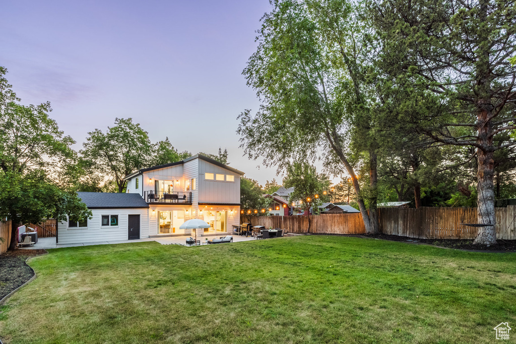 Fenced backyard with a balcony and a patio area