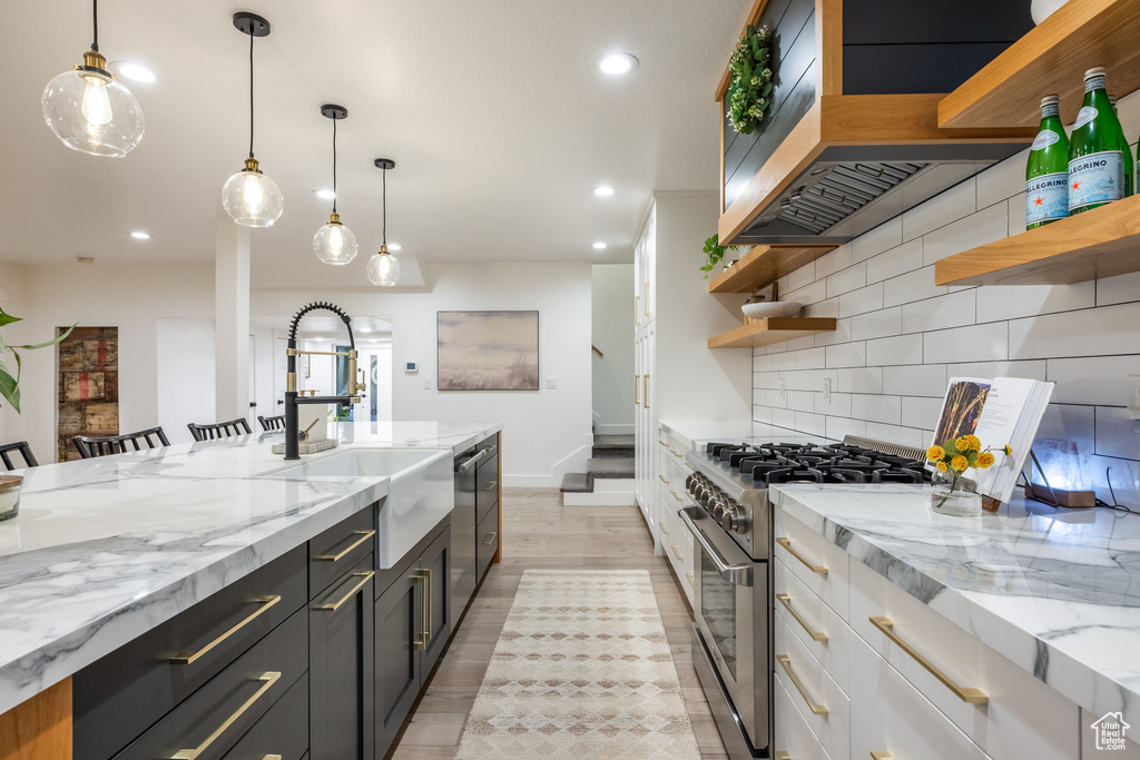 Kitchen featuring open shelves, appliances with stainless steel finishes, decorative backsplash, recessed lighting, and light stone countertops