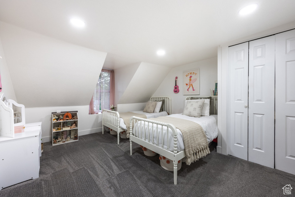 Bedroom featuring dark carpet, recessed lighting, vaulted ceiling, and a closet