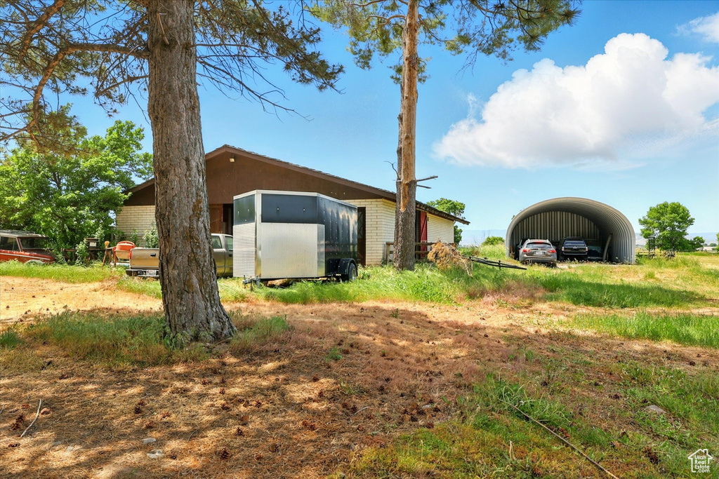 View of yard featuring a carport and dirt driveway