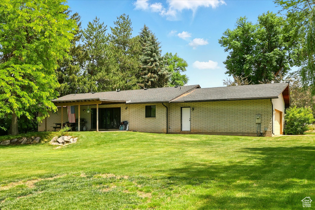 Back of property featuring a garage and a yard