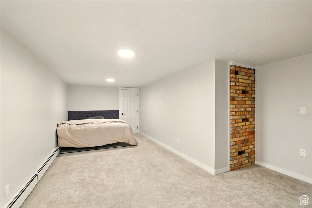 Carpeted bedroom with baseboard heating and baseboards