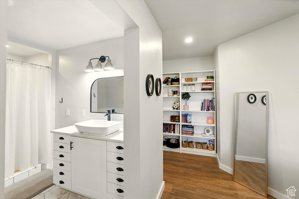 Bathroom with vanity, a shower with shower curtain, wood finished floors, and recessed lighting