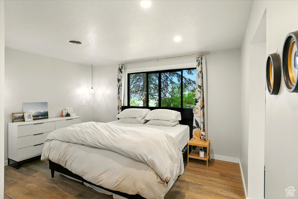 Bedroom with wood finished floors and recessed lighting