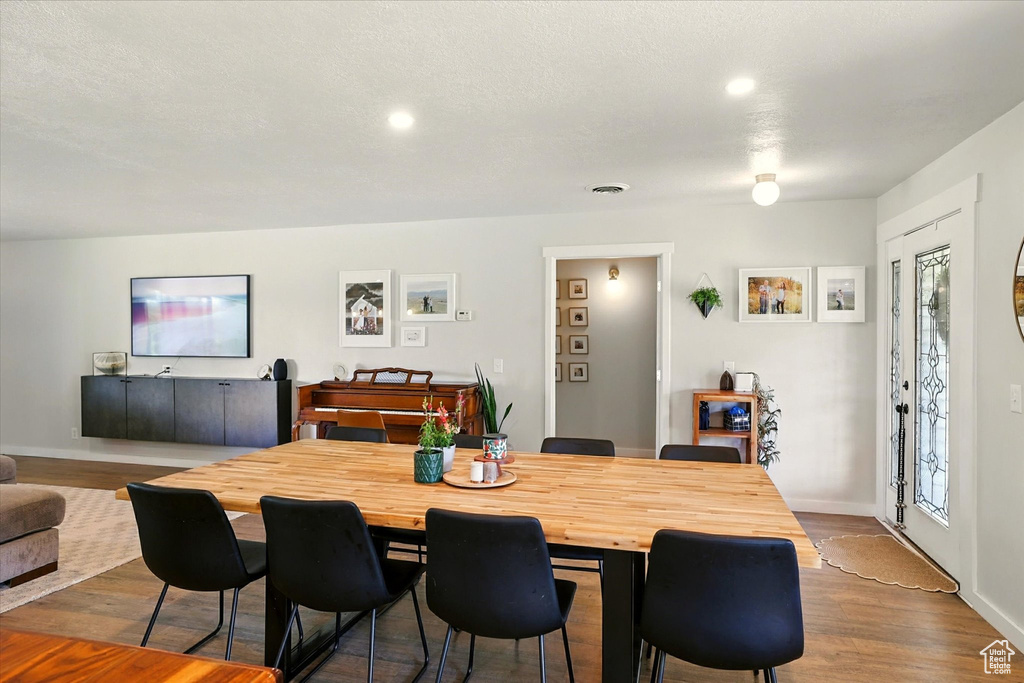 Dining space featuring dark wood-style flooring and recessed lighting