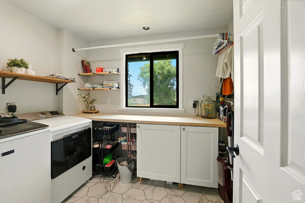 Washroom with washer and clothes dryer and cabinet space
