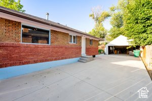 Exterior space featuring entry steps, an outdoor structure, and brick siding