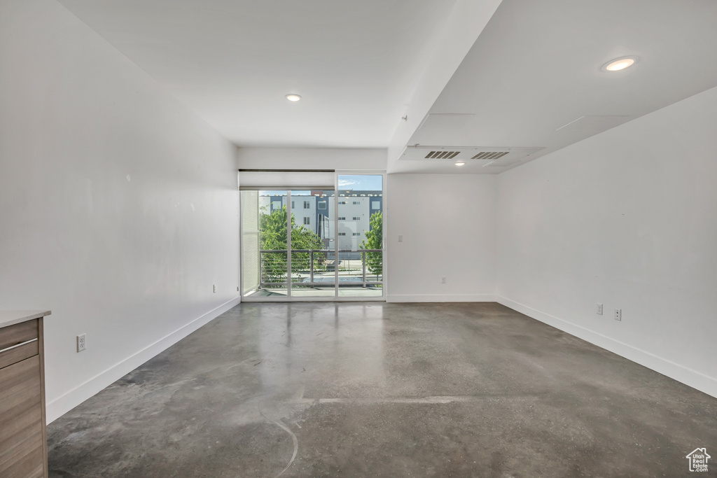 Spare room with concrete flooring and recessed lighting