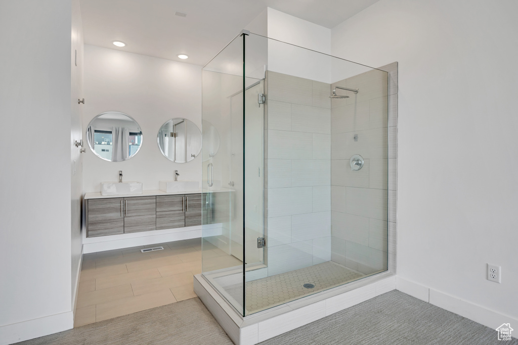 Full bathroom with double vanity, a shower stall, and recessed lighting