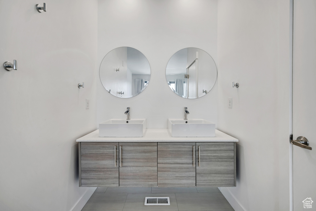 Full bathroom with baseboards and double vanity