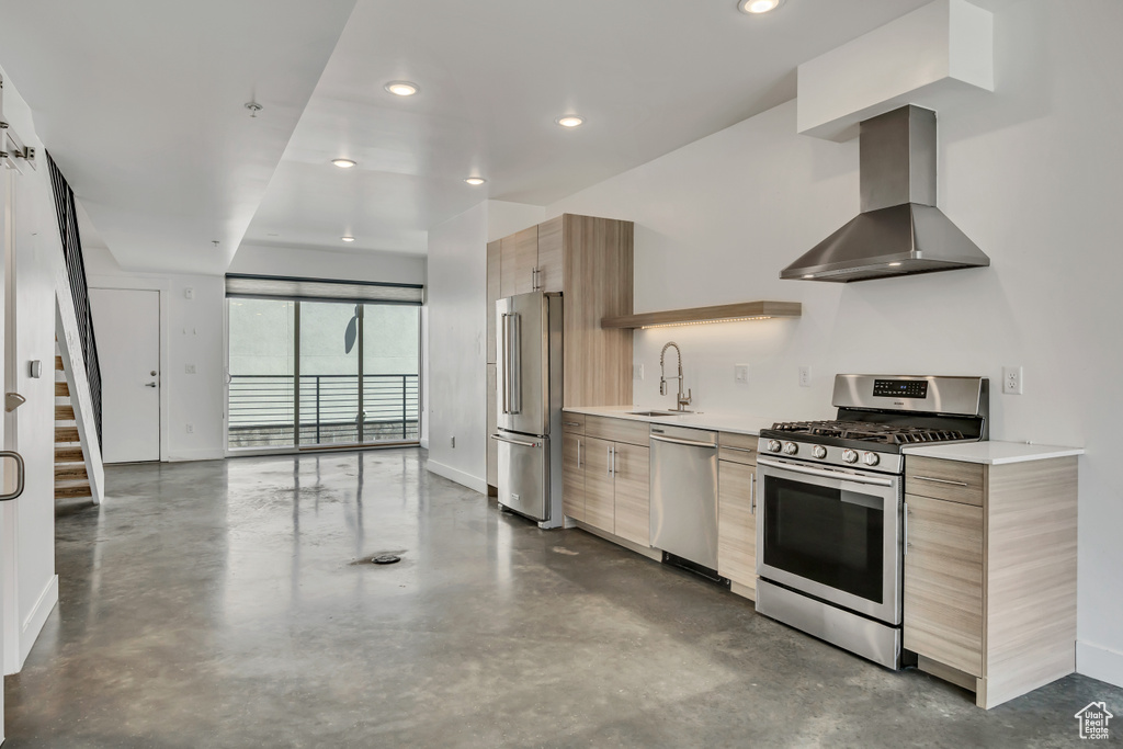 Kitchen with stainless steel appliances, wall chimney exhaust hood, modern cabinets, finished concrete floors, and recessed lighting