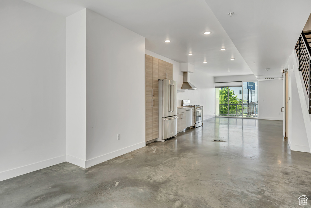Unfurnished living room featuring finished concrete flooring and recessed lighting