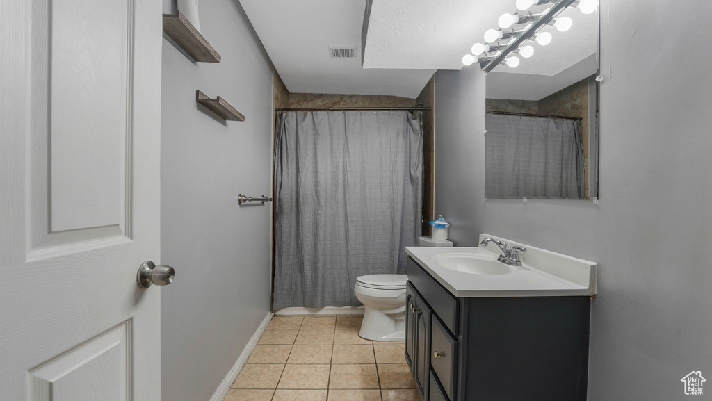 Full bath featuring vanity, tile patterned floors, and curtained shower