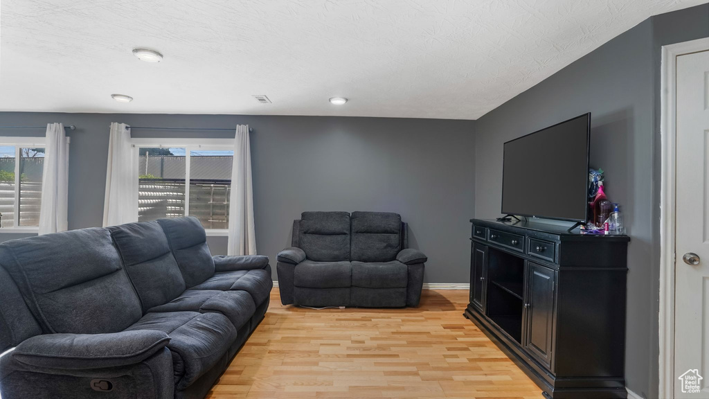 Living area with light wood finished floors and baseboards